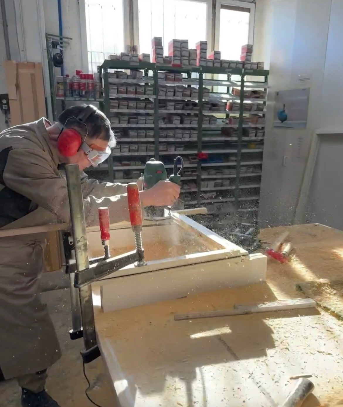 Bautischler bei der Instandsetzung eines historischen Holzfensters in der Werkstatt