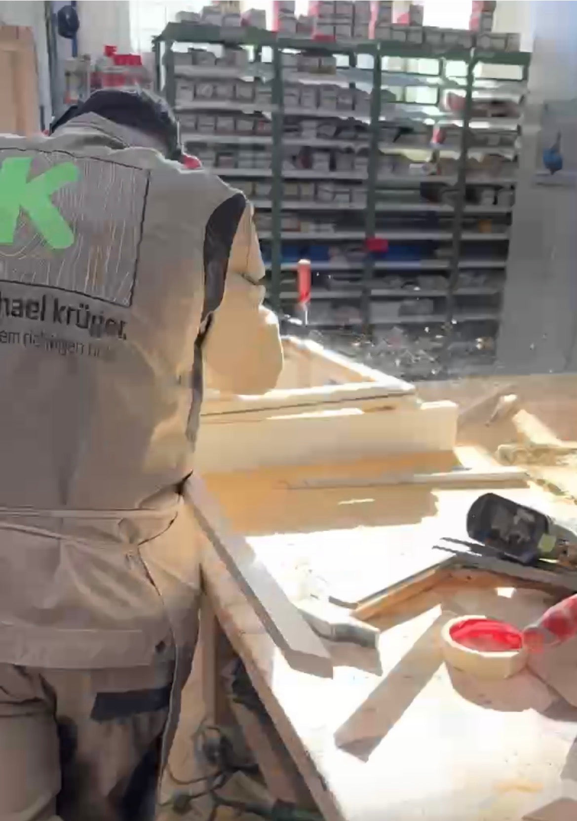 Bautischler bei der Reparatur historischer Holzbauteile in der Werkstatt, präzise Handarbeit an Tür- und Rahmenelementen.